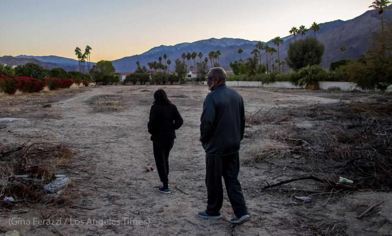 Joe Abner and his wife, Vera, walk through a vacant lot that was once part of the Section 14 community in Palm Springs. Abner was 13 when his family fled Section 14, which the city ultimately leveled to make way for luxury developments in the 1960s. Photo by Gina Ferazzi Los Angeles Times